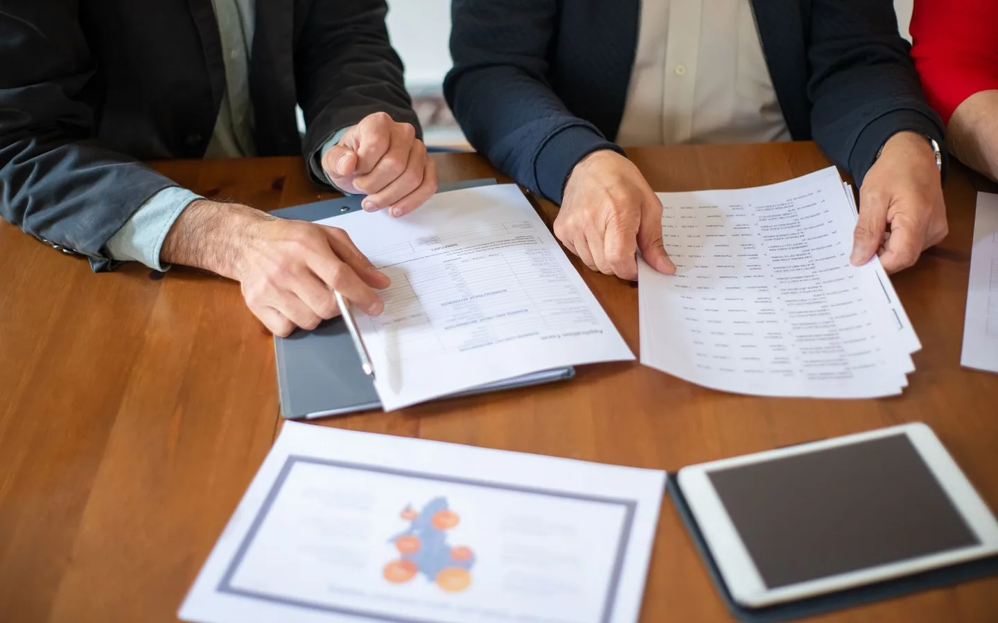 Colleagues reviewing documents around a meeting table.