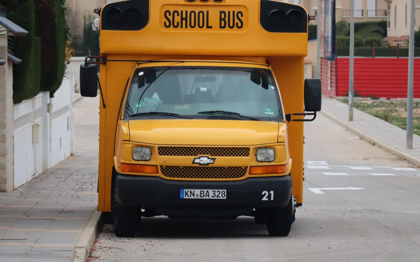 A yellow school bus parked beside a street.